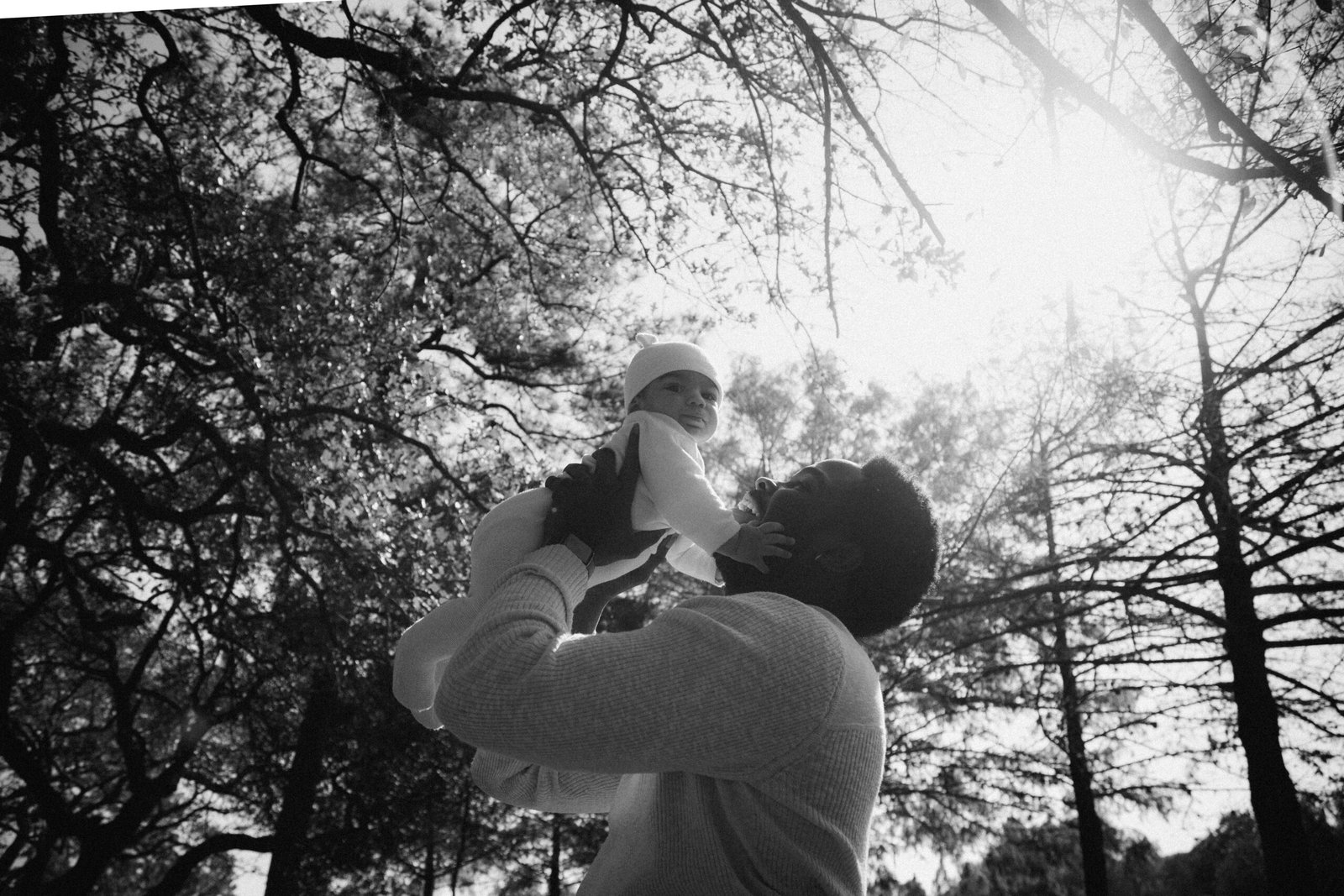 Father lifting child in black and white